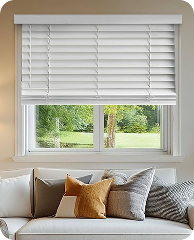 White horizontal blinds installed above a living room sofa